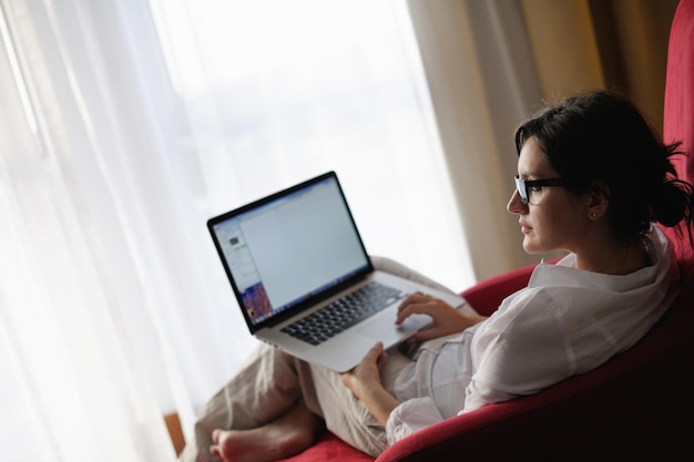 Bela jovem usando um laptop em casa