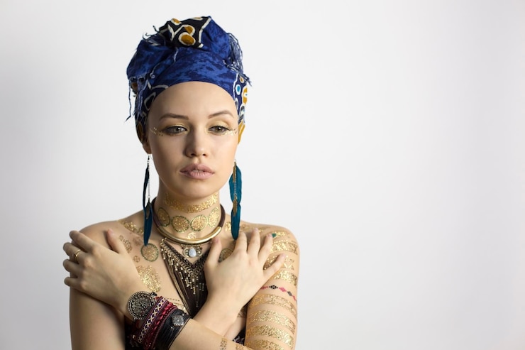 Foto bela jovem vestida com roupas tradicionais sobre fundo branco
