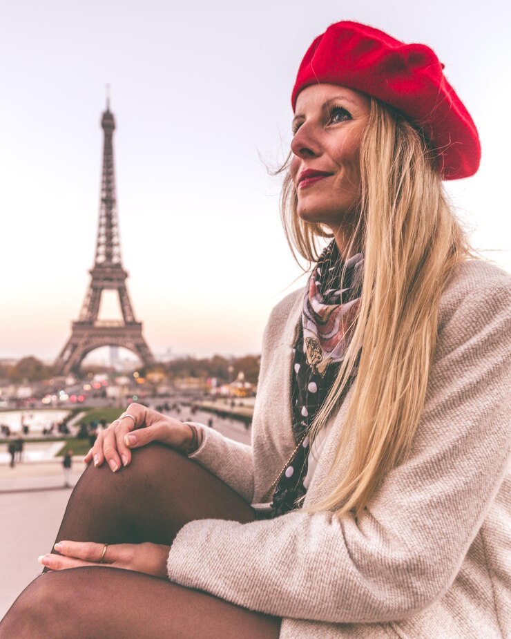 Foto bela jovem vestindo chapéu contra a torre eiffel na cidade