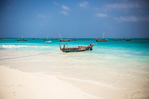 Bela linha costeira de Zanzibar. Barco de pesca de madeira no mar com fundo de água azul, Zanzibar,