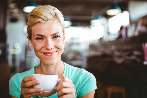 Bela loira segurando xícara de café