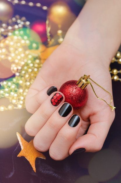 Bela mão feminina com design de unhas de Natal