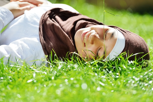 Bela menina árabe muçulmana com tempo feliz na natureza