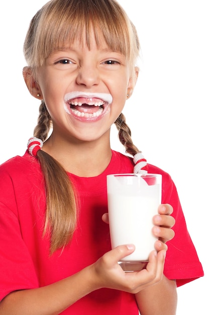 Foto bela menina sorridente com um copo de leite em fundo branco