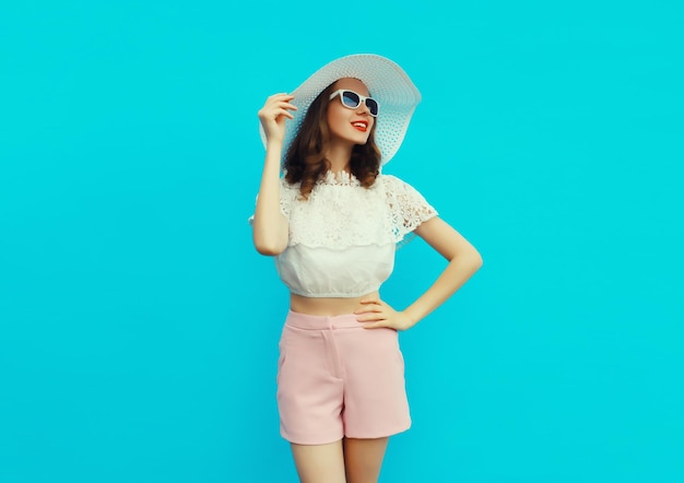 Bela modelo jovem caucasiana posando vestindo um chapéu branco de palha de verão