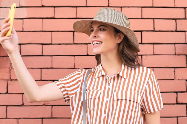 Bela modelo morena sorridente vestida com roupas de verão moderno. Mulher engraçada e positiva se divertindo.