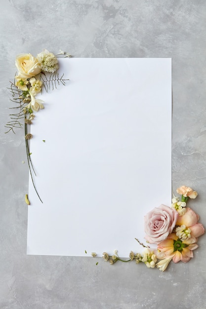 bela moldura com flores e um papel branco com espaço para texto em fundo cinza de concreto, plano leigo