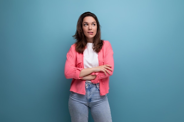 Bela morena europeia de camisa rosa com inspiração no fundo do estúdio com cópia