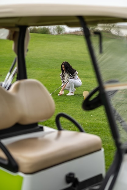 Bela mulher a jogar golfe no gramado verde.