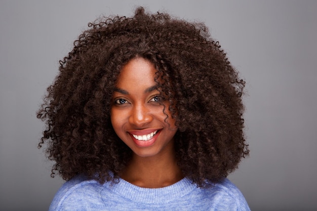 Bela mulher afro-americana com cabelos encaracolados em fundo cinzento