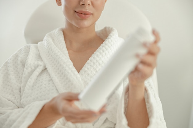 Bela mulher caucasiana sorridente e saudável está realizando procedimentos de beleza no spa e salão de saúde.