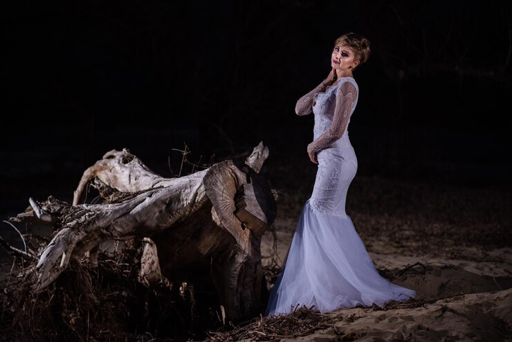 Foto bela mulher de pé em terra à noite