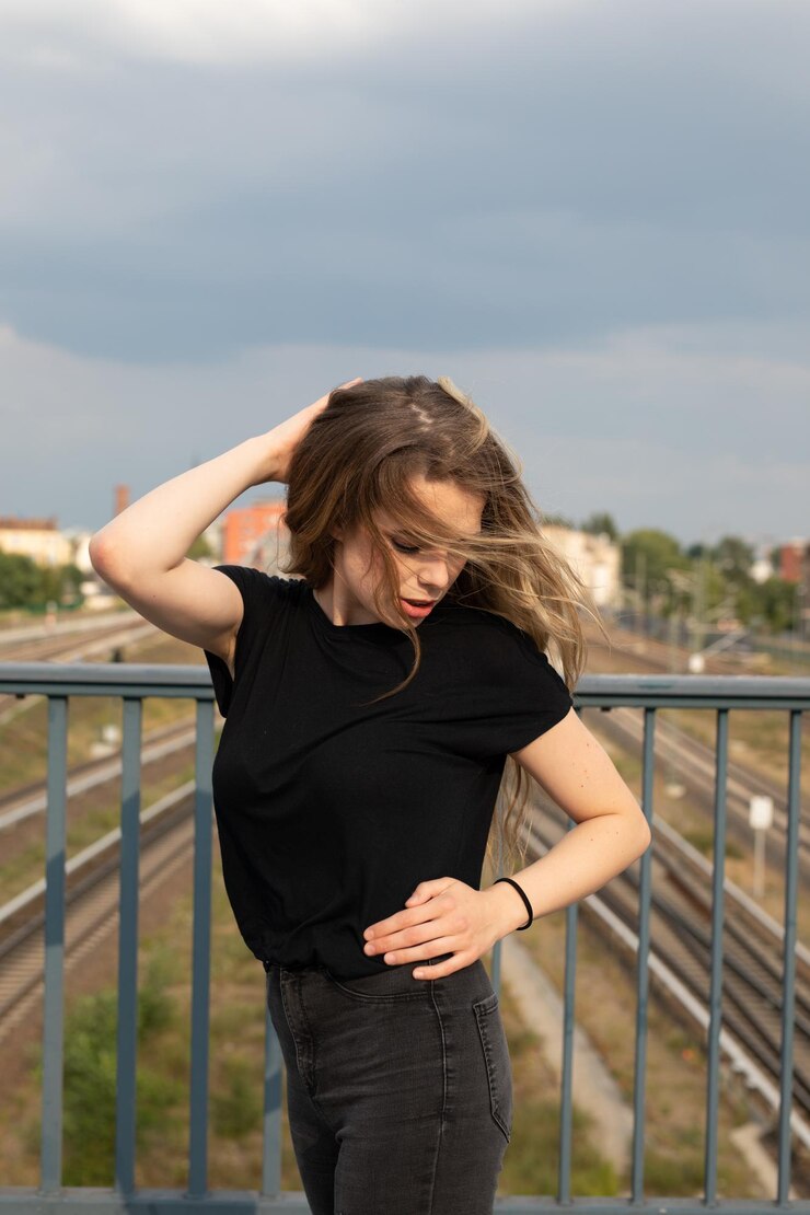 Foto bela mulher de pé por corrimão contra o céu
