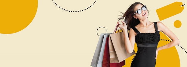 Bela mulher de raça mista segurando sacos de compras e sorrindo