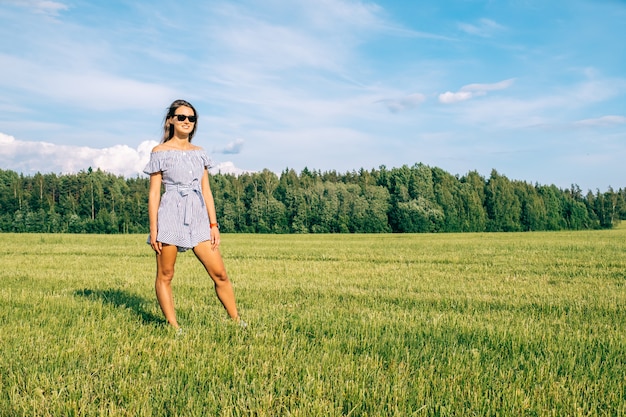 Bela mulher de vestido em campo verde