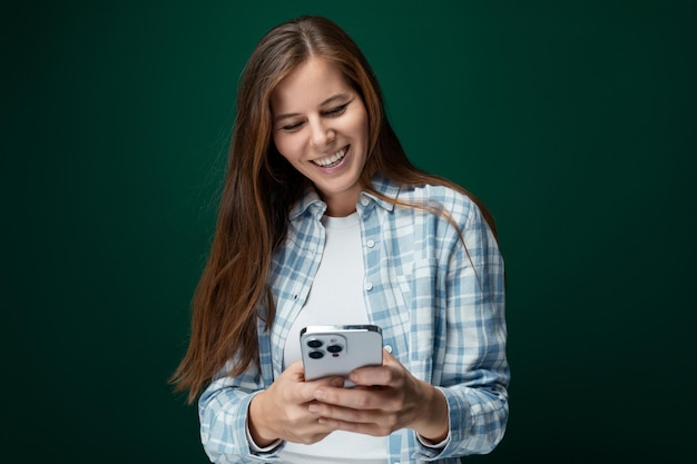 Foto bela mulher europeia com cabelo castanho saudável vestindo uma camisa em um fundo de estúdio verde