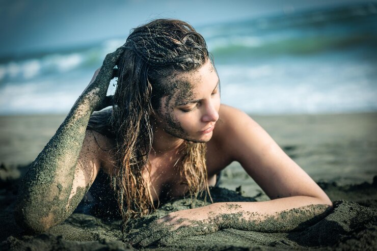 Foto bela mulher sensual deitada na areia da praia