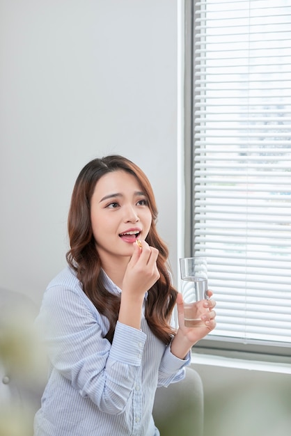 Bela mulher sorridente tomando pílula de vitamina. Suplemento dietético