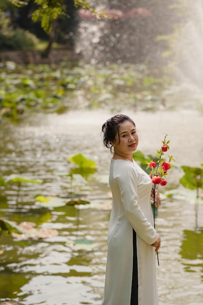 Bela mulher vietnamita em vestido ao dai ao ar livre
