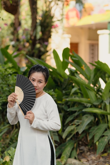 Bela mulher vietnamita em vestido ao dai ao ar livre