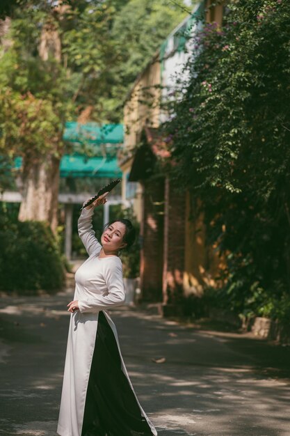 Bela mulher vietnamita em vestido ao dai ao ar livre