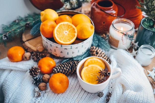 Bela natureza morta de Natal Uma xícara de chá quente com uma sexta manta de malha no peitoril da janela com decoração de Ano Novo