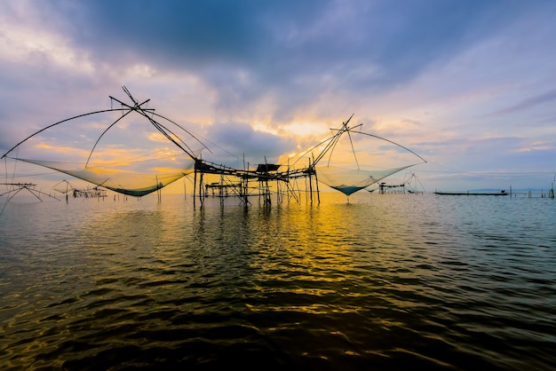 Bela natureza paisagem luz dourada do céu da manhã ao nascer do sol e estilo de vida rural de ferramenta de pesca nativa no canal Pakpra, lago Songkhla, Baan Pak Pra é um famoso ponto de referência de Phatthalung, Tailândia