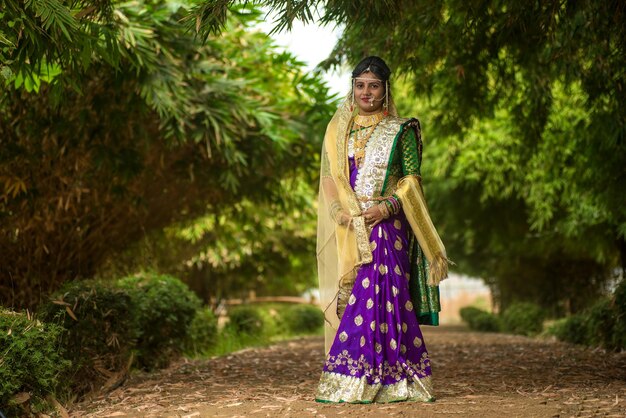 Bela noiva indiana em sari tradicional posando ao ar livre no parque