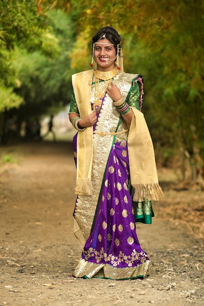 Bela noiva indiana em sari tradicional posando ao ar livre no parque