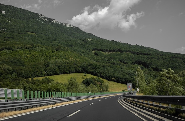 Bela paisagem cênica em montanhas cobertas de florestas vista da janela do carro em uma estrada moderna e de alta qualidade