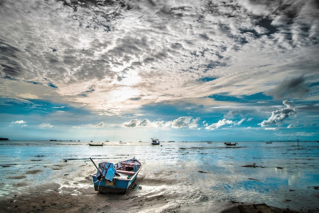 Bela paisagem com barco solitário um sol, majestosas nuvens no céu