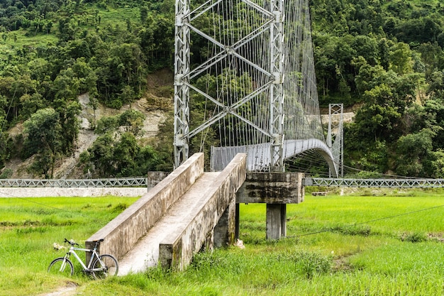 Bela paisagem com bicicleta branca estacionada na ponte pênsil para pedestres