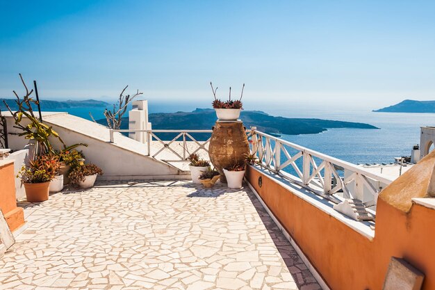 Bela paisagem com vista para o mar. Flores no terraço. Ilha de Santorini, Grécia.