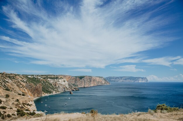 Bela paisagem contra o pano de fundo das montanhas e o mar com iates brancos como a neve.