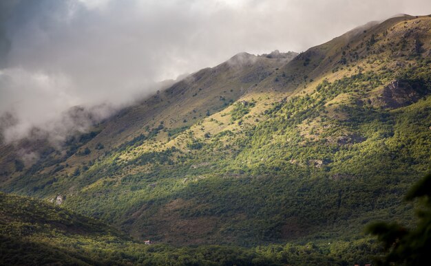 Bela paisagem de altas montanhas cultivadas com grama coberta de nuvens