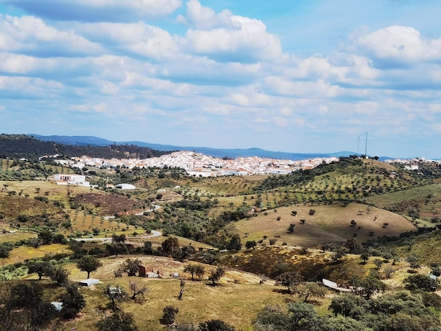 Bela paisagem de colinas verdes com árvores com nuvens brancas