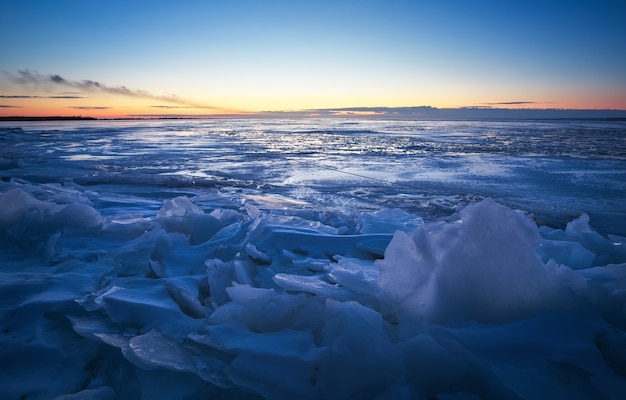 Foto bela paisagem de inverno com céu ardente ao pôr do sol e lago congelado