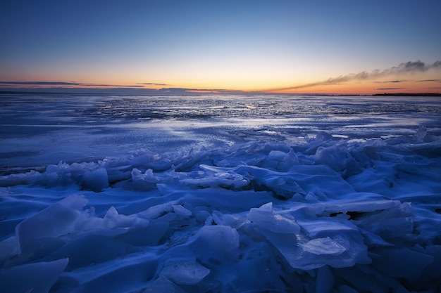 Bela paisagem de inverno com céu ardente ao pôr do sol e lago congelado