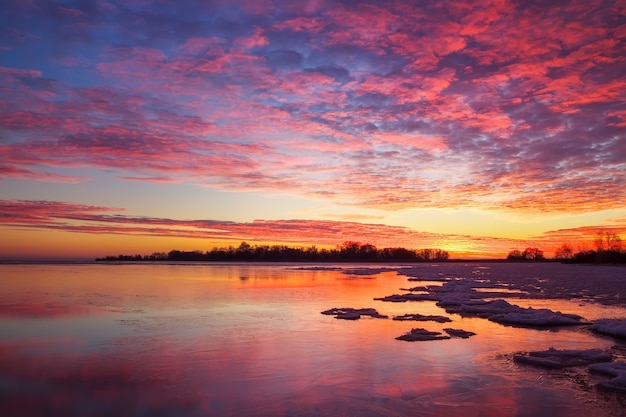 Bela paisagem de inverno com céu ardente do sol e lago congelado. composição da natureza.