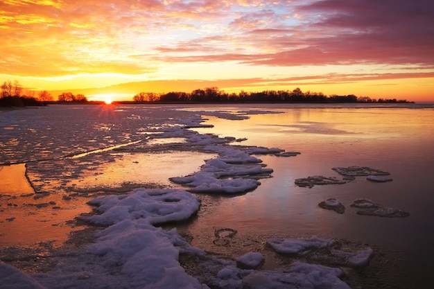 Bela paisagem de inverno com céu ardente do sol e lago congelado. Composição da natureza.