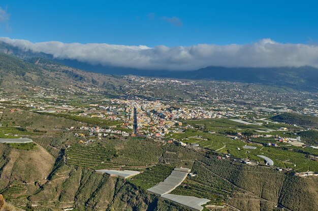 Bela paisagem de uma pequena aldeia agrícola em uma tarde ensolarada perto de uma rodovia ou estrada movimentada para logística ou transporte de mercadorias Plantações de banana na cidade de Los Llanos La Palma Espanha