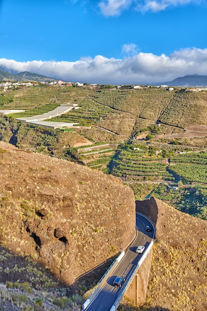 Bela paisagem de uma pequena vila agrícola em uma tarde ensolarada perto de uma rodovia ou estrada movimentada para logística ou transporte de mercadorias Plantações de banana na cidade Los Llanos La Palma Espanha