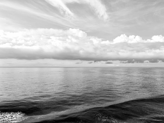 Bela paisagem marinha com água ondulada do mar oceânico e céu azul com nuvens brancas como pano de fundo natural