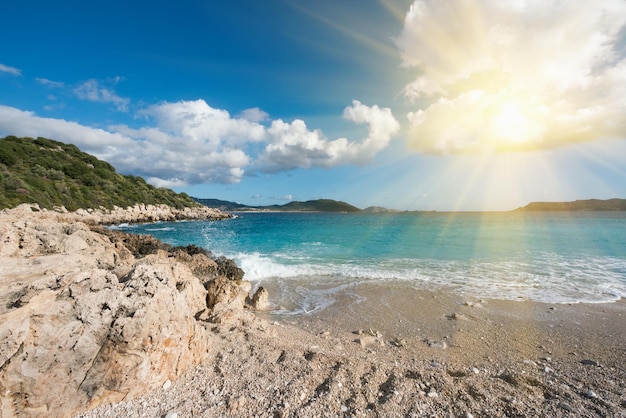 Bela paisagem marinha verde costa rochosa praia arenosa e água azul à luz do sol
