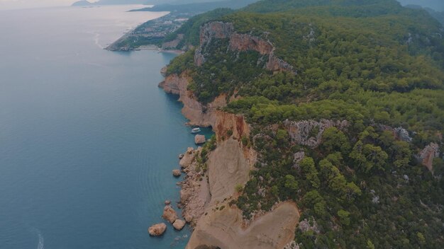 Bela paisagem marítima Vista superior de uma costa rochosa coberta de árvores verdes Água azul Vista aérea de drones