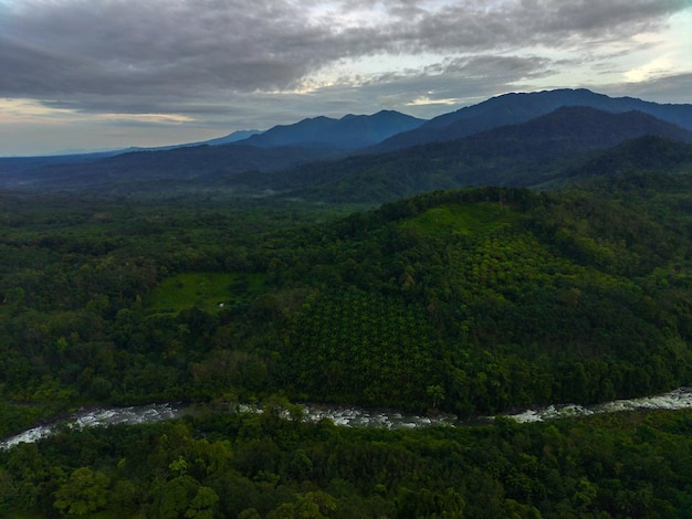 Bela paisagem matinal indonésia Foto aérea do rio entre montanhas e florestas