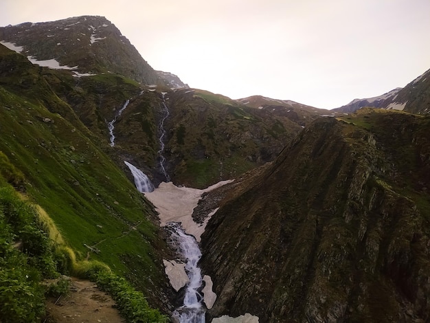 Bela paisagem montanhosa com uma cachoeira no meio do vale