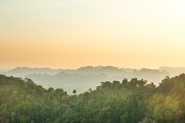 Bela paisagem tropical com floresta tropical de montanha e cume rochoso íngreme no horizonte ao pôr do sol. Krabi, Tailândia