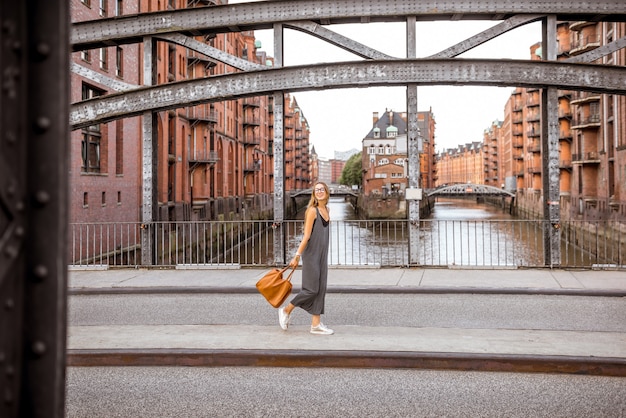 Bela ponte de ferro com mulher caminhando em Speicherstadt, distrito histórico de armazéns em Hamburgo, Alemanha