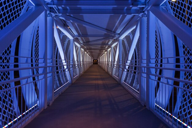 Bela ponte de pé com luzes de cor azul à noite Caminho ao longo da ponte Transição